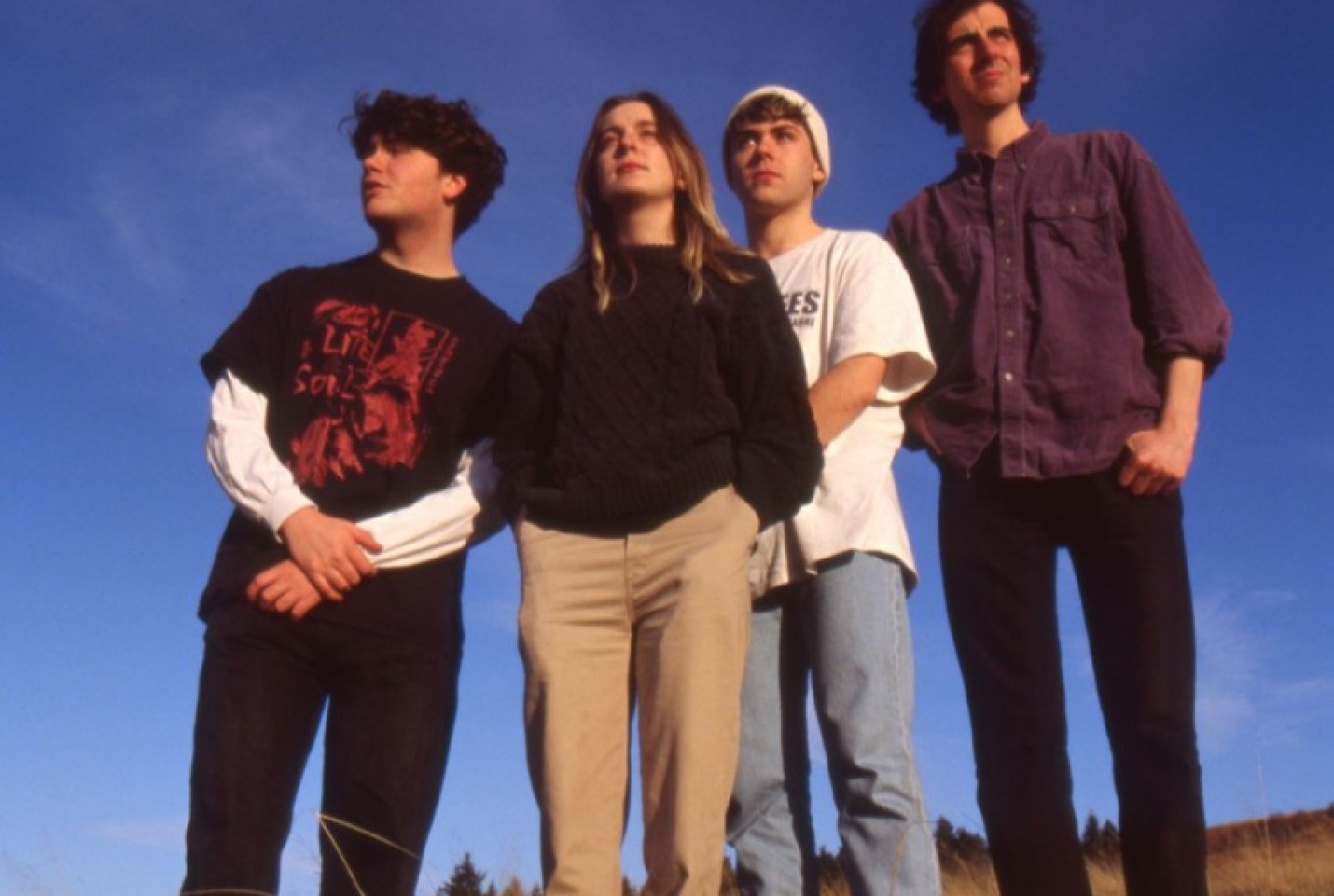 The band Dallas Love Field, with the members standing on a hill looking into the distance.